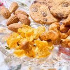 Spicy Cornflakes Medley with roasted almonds, honey roasted cashews and Chocolate Chip cookies on a glass plate