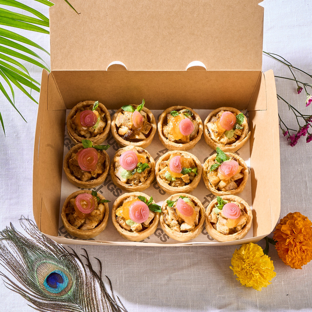 Box of 12 halal Chicken Tikka Tarts for Deepavali, each topped with a pickled onion rose and mint
