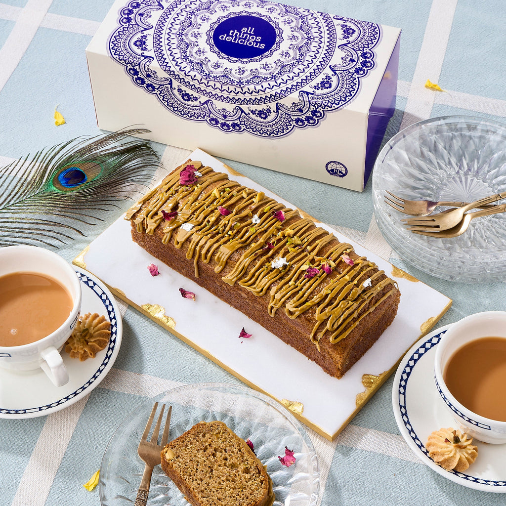 Halal Pistachio Cardamom Voyage Cake with pistachio praline drizzle and rose petals, served with masala chai