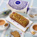 Halal Pistachio Cardamom Voyage Cake with pistachio praline drizzle and rose petals, served with masala chai