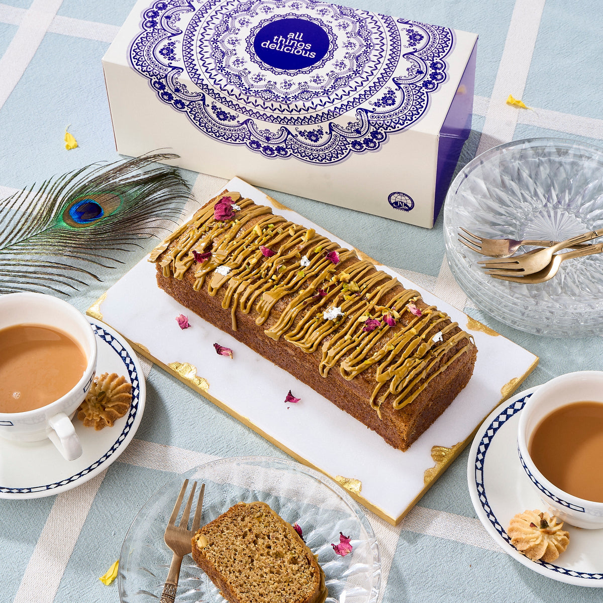 Halal Pistachio Cardamom Voyage Cake with pistachio praline drizzle and rose petals, served with masala chai